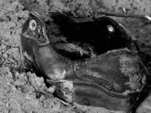 Fig. 5 (Sylvain George, 'Qu’Ils reposent en révolte', a shoe half buried in the sand, 02.23.06)