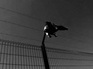 Fig. 6 (Sylvain George, 'Qu’Ils reposent en révolte', clothing on barbed wire fence, 00.21.58)